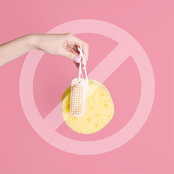 hand with loofa holding it pink background and a transparent stop sign